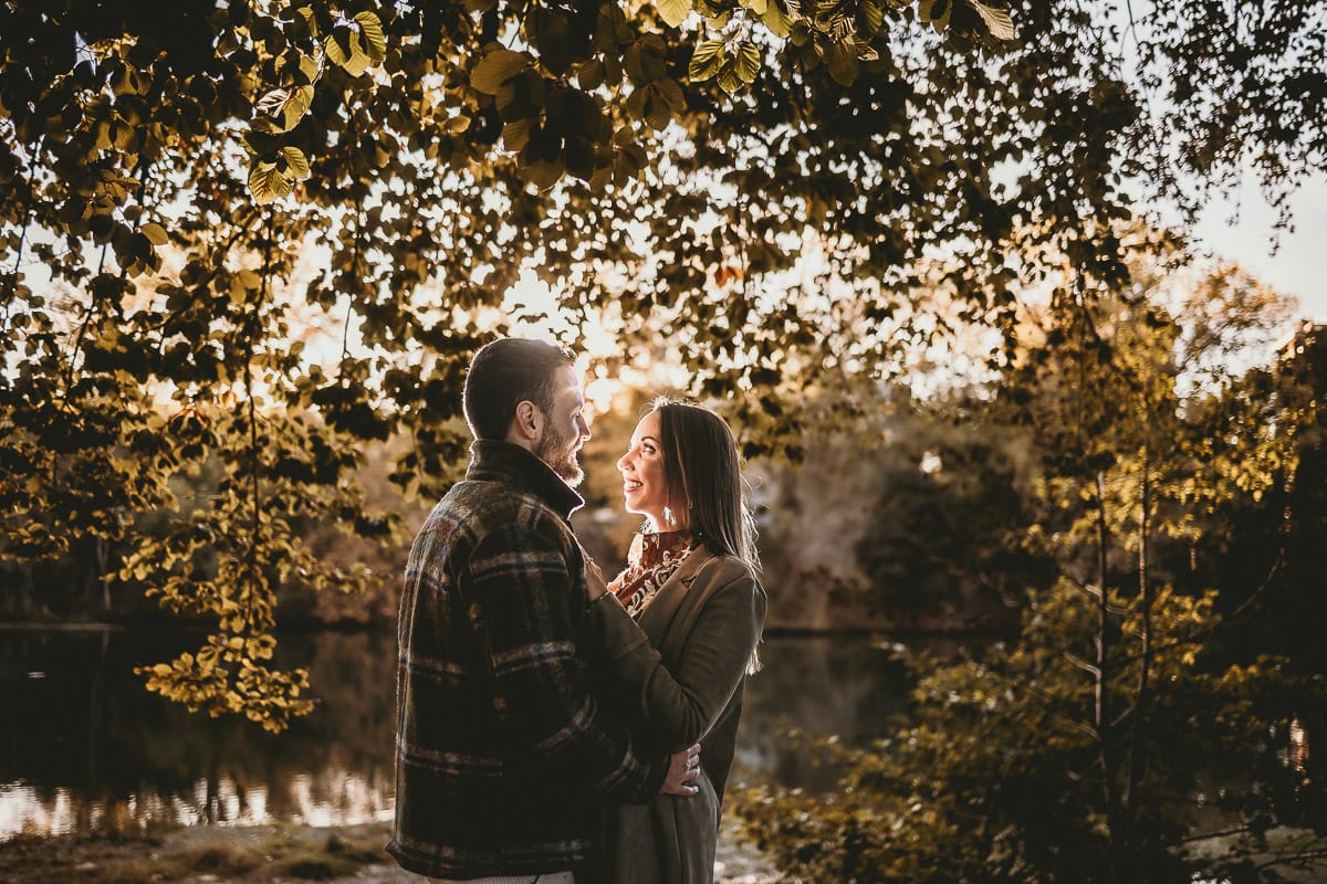 Prewedding a Torino, sul lungo Po al tramonto. Ritratto sulla riva del fiume con la magia dell'autunno sull'acqua. Coppia in controluce. Flare.