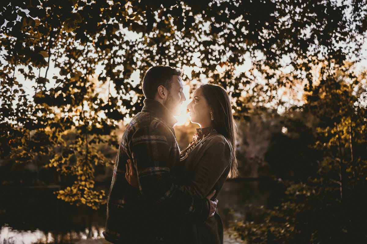 Prewedding a Torino, sul lungo Po al tramonto. Ritratto sulla riva del fiume con la magia dell'autunno sull'acqua. Coppia in controluce. Flare.
