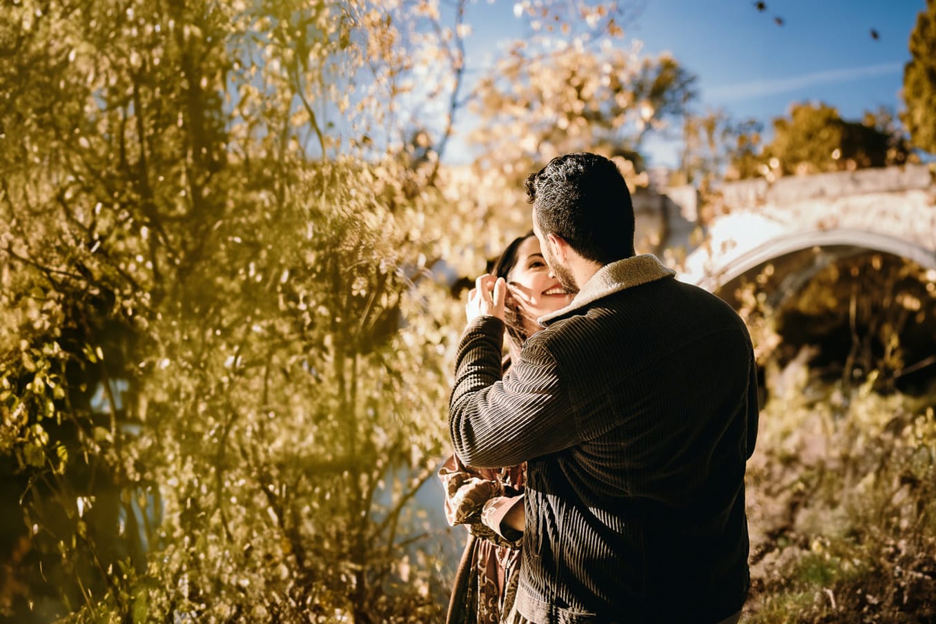 Prewedding a Torino, sul lungo Po al tramonto. La coppia si guarda davanti al ponte sul Po.