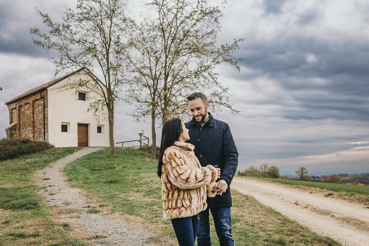 Fotografia di coppia invernale presso la chiesa di San Lorenzo di Mombello di Torino. Barbara e Riccardo camminano davanti alla chiesetta