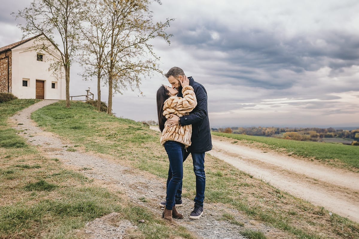 Fotografia di coppia invernale presso la chiesa di San Lorenzo di Mombello di Torino. Barbara e Riccardo si baciano davanti alla chiesetta