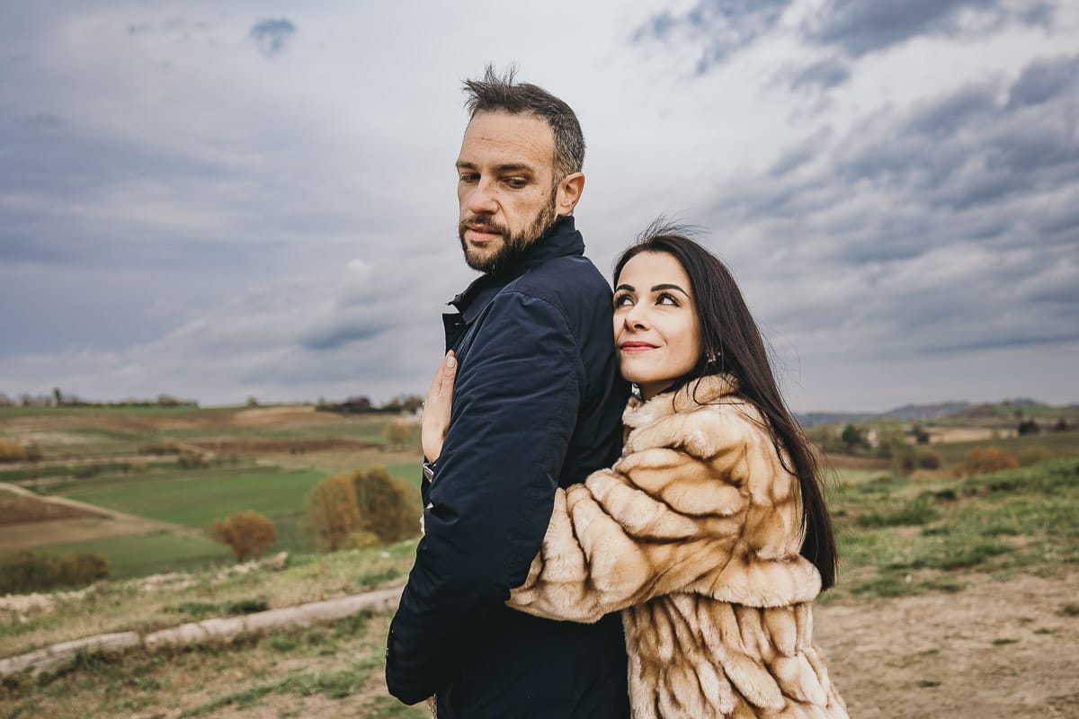 Fotografia di coppia invernale presso la chiesa di San Lorenzo di Mombello di Torino. Barbara abbraccia Riccardo da dietro