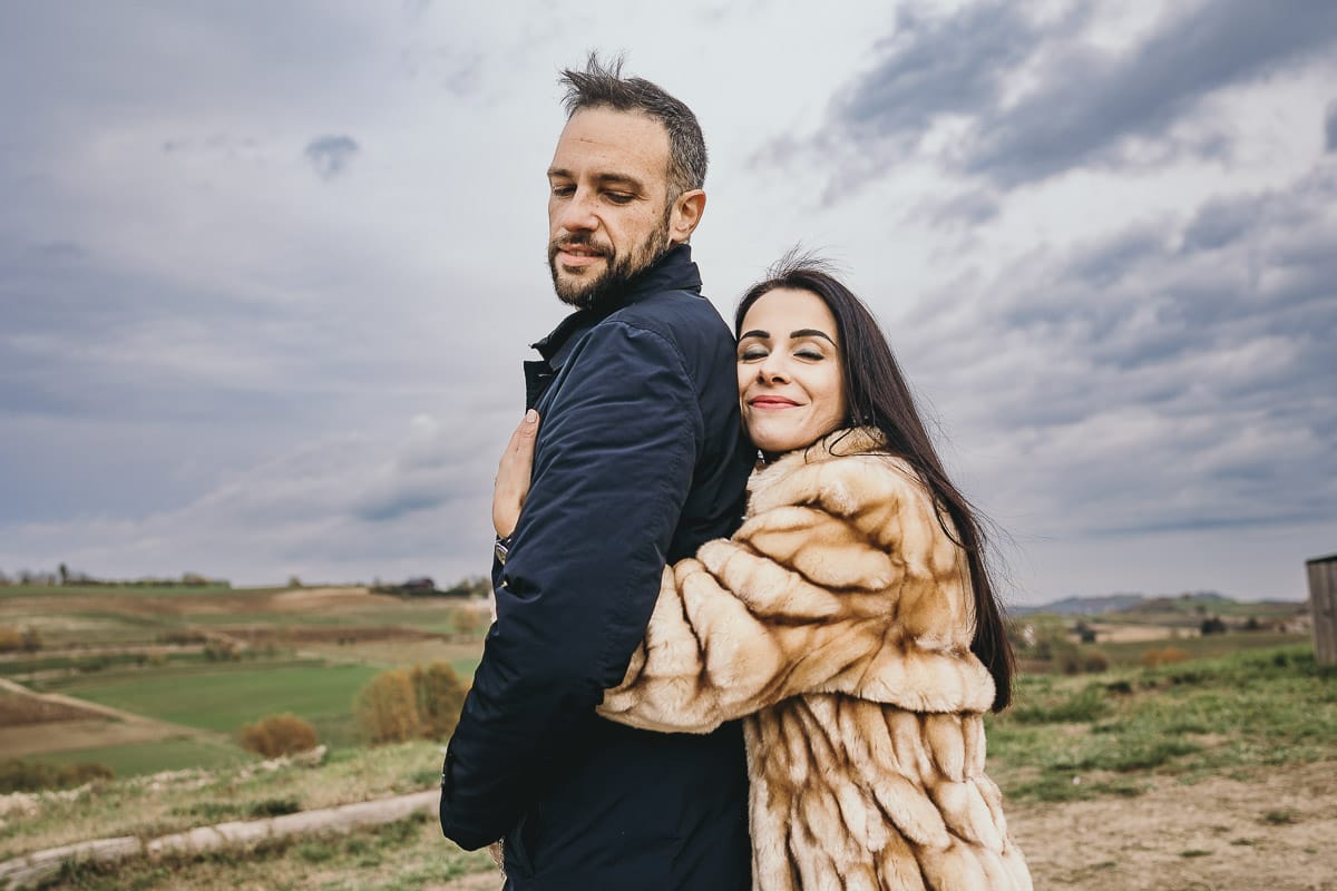 Fotografia di coppia invernale presso la chiesa di San Lorenzo di Mombello di Torino. Barbara abbraccia Riccardo da dietro