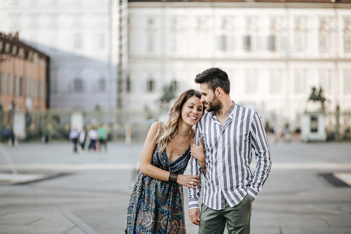Prewedding nel centro di Torino Elisa e Davide camminano in piazza Castello davanti a Palazzo Reale
