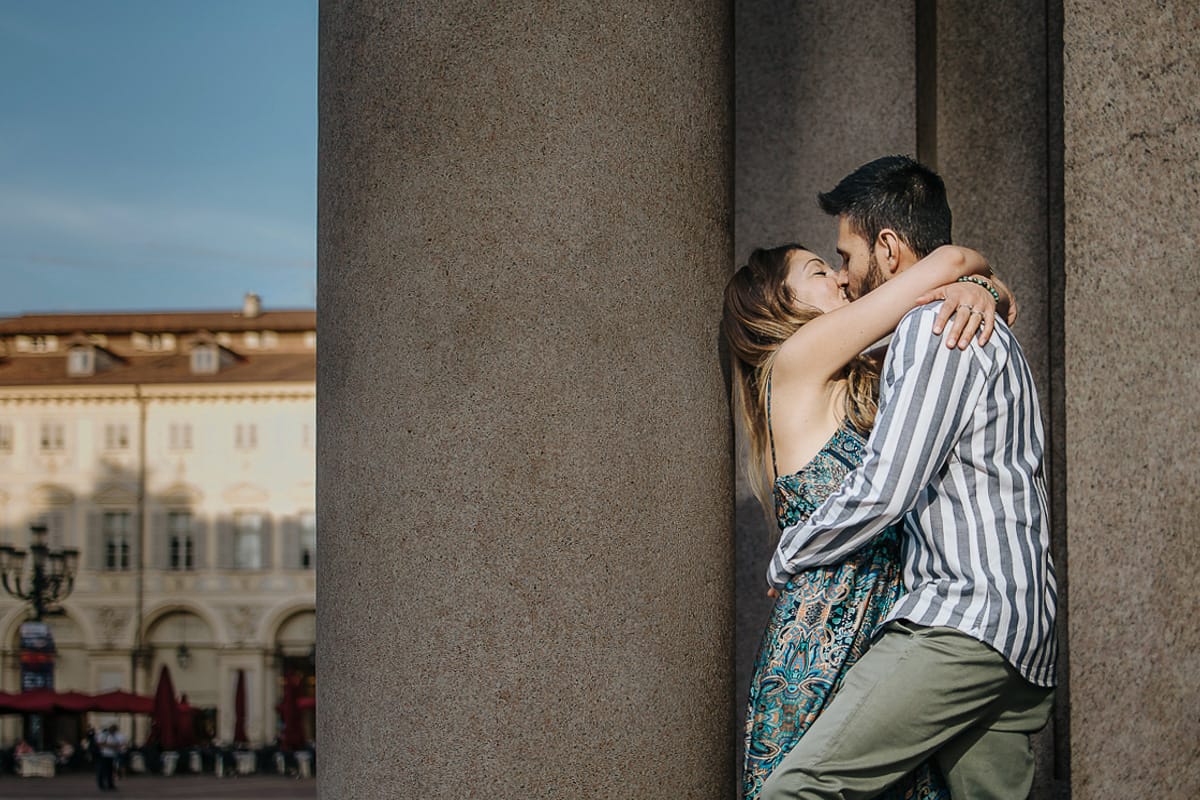 Prewedding nel centro di Torino Elisa e Davide in piazza San Carlo si baciano tra le colonne