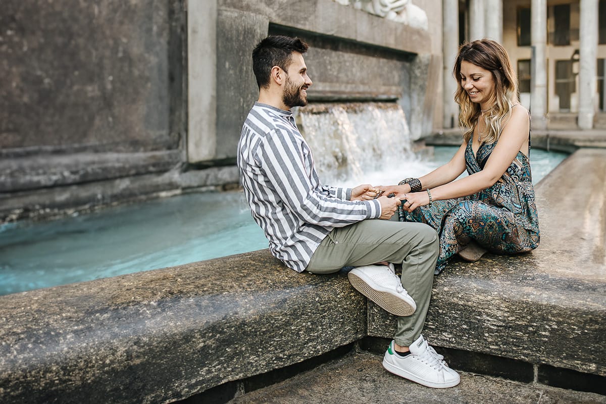 Prewedding nel centro di Torino Elisa e Davide in piazza San Carlo seduti sulla fontana di piazza CLN