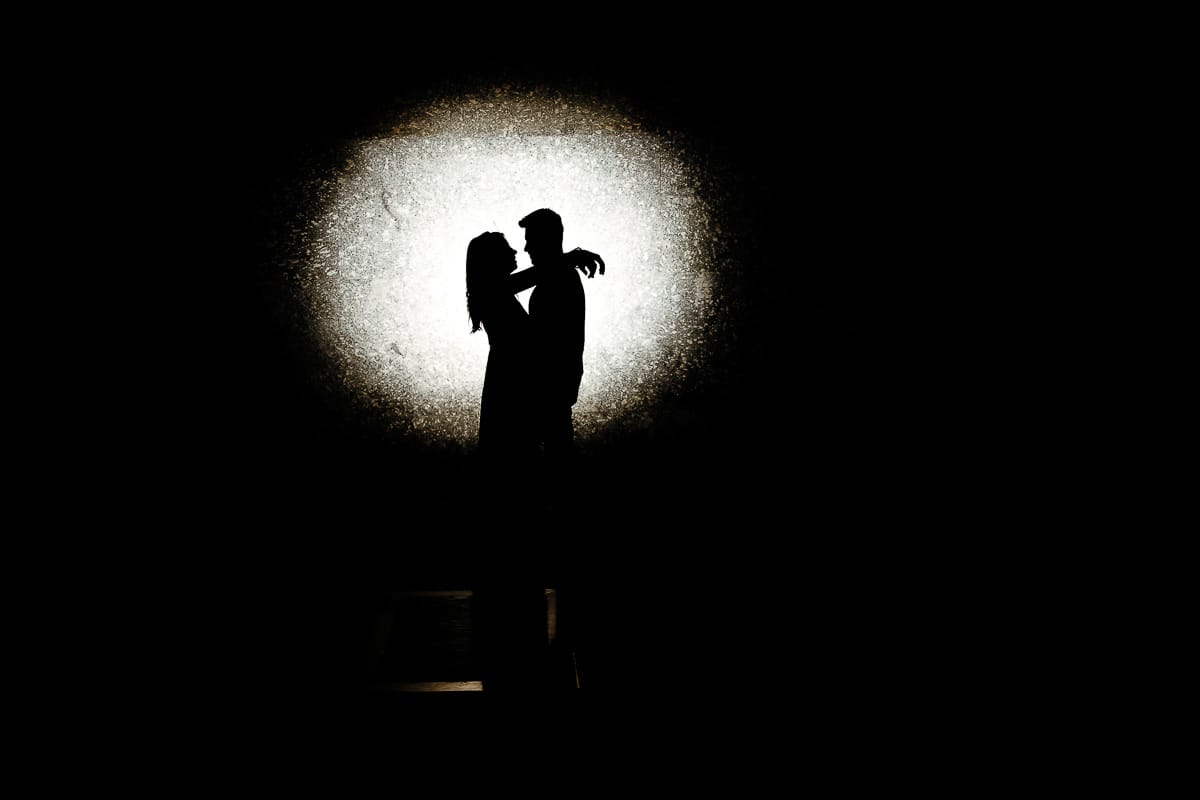 Prewedding nel centro di Torino Elisa e Davide in piazza CLN ritratto con flash esterno che crea cerchio di luce dietro la coppia. Silhouette