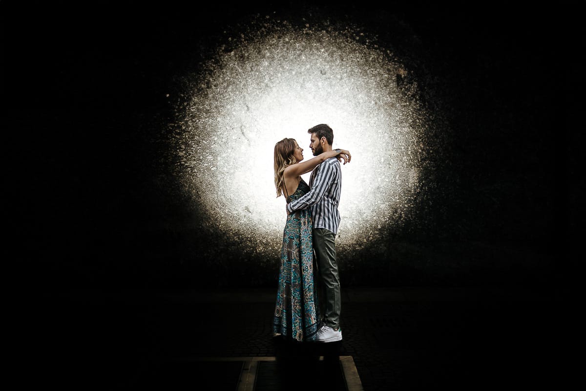 Prewedding nel centro di Torino Elisa e Davide in piazza CLN ritratto con flash esterno che crea cerchio di luce dietro la coppia.