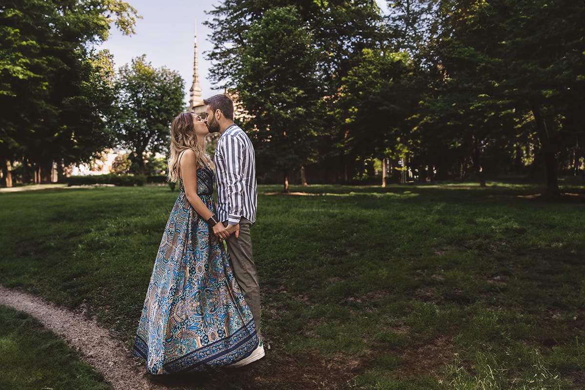 Prewedding nel centro di Torino . Elisa e davide si baciano nei Giardini Reali. Sullo sfondo la guglia della Mole Antonelliana.