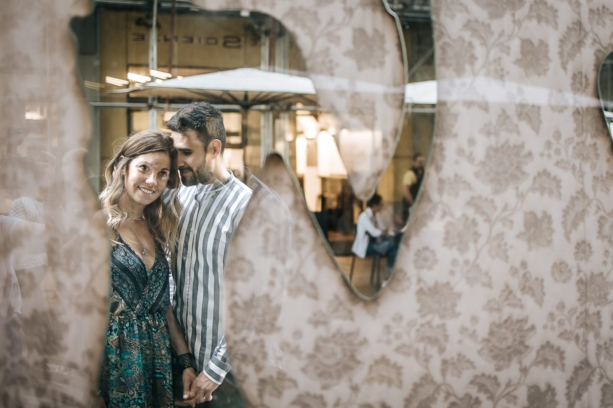 Prewedding nel centro di Torino Elisa e Davide in piazza Carignano riflessi nello specchio di un negozio