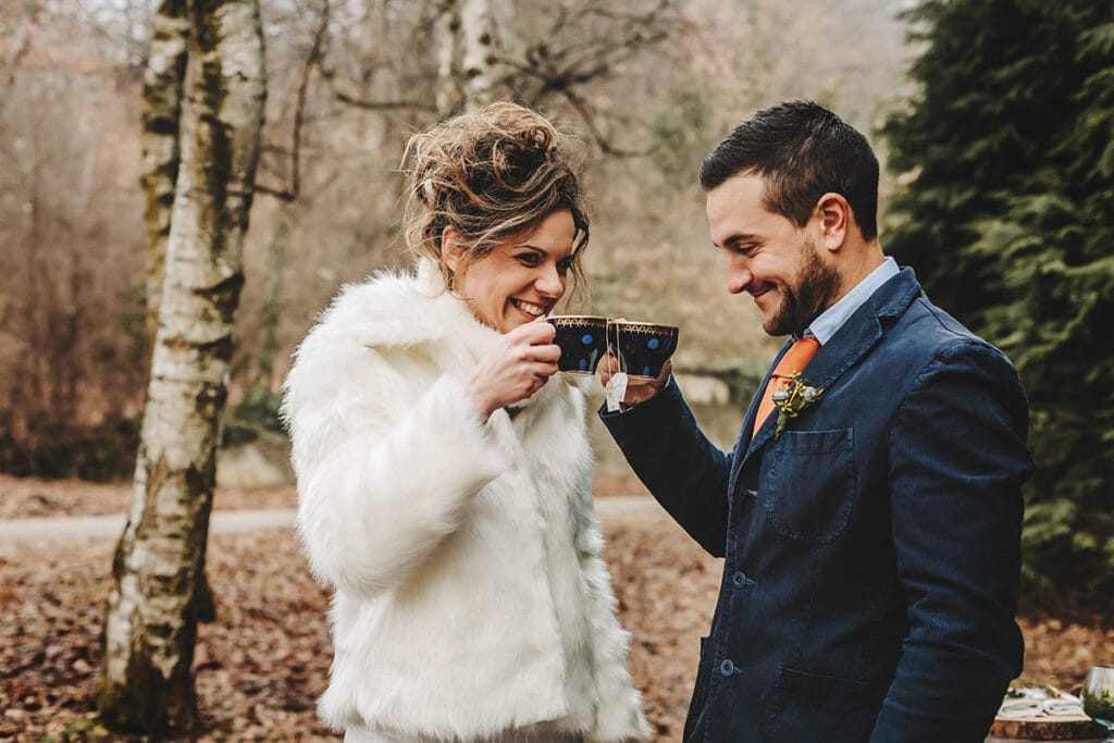Winter wedding at the Superga hill park, among coniferous trees reminiscent of the great parks of North America. The bride and groom warm up with a comforting hot tea.