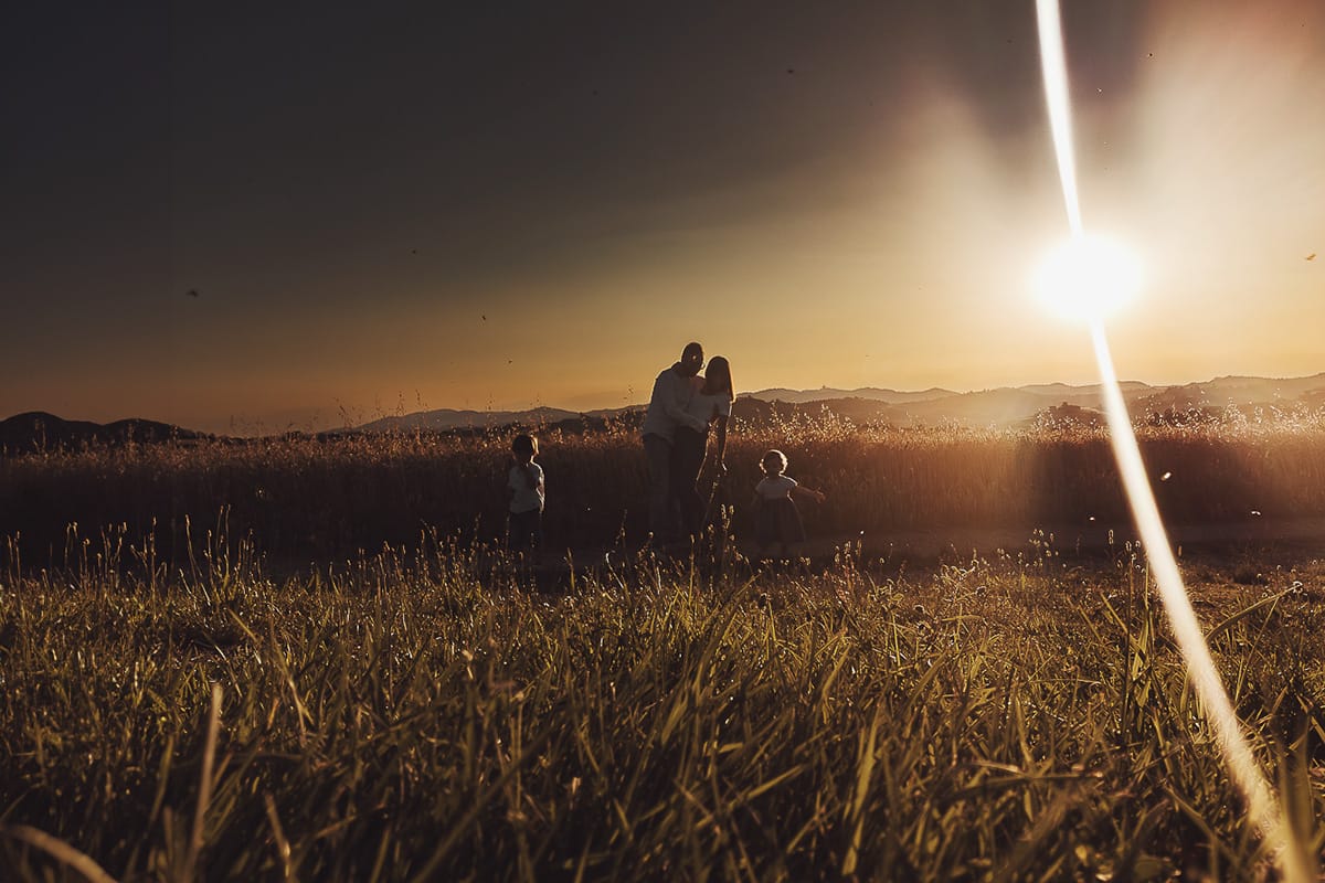 Fotografia di famiglia al tramonto. Ritratto di coppia dei genitori con la splendida luce del tramonto
