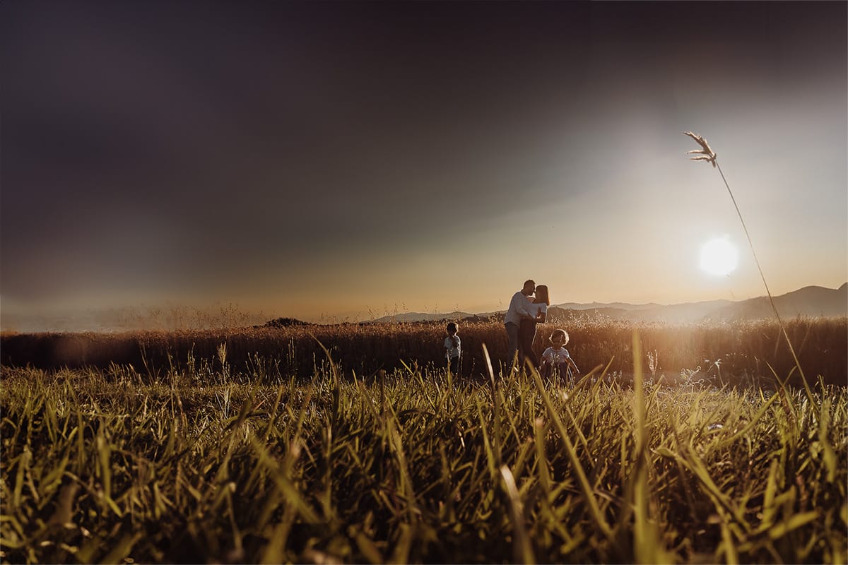 Fotografia di famiglia al tramonto. Ritratto di coppia dei genitori con la splendida luce del tramonto