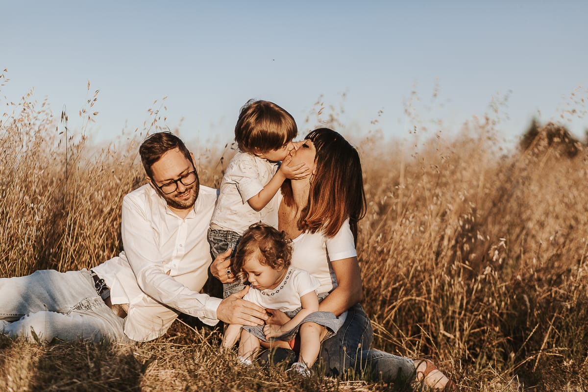 Un ritratto di famiglia al tramonto: Ilenia, Filippo, Edo e Camilla, uniti dal loro amore.. Edo bacia la mamma.