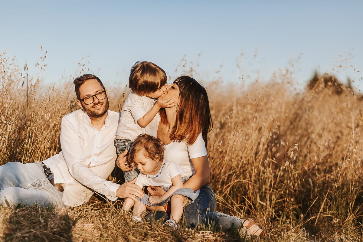 Un ritratto di famiglia al tramonto: Ilenia, Filippo, Edo e Camilla, uniti dal loro amore. Edo bacia la mamma