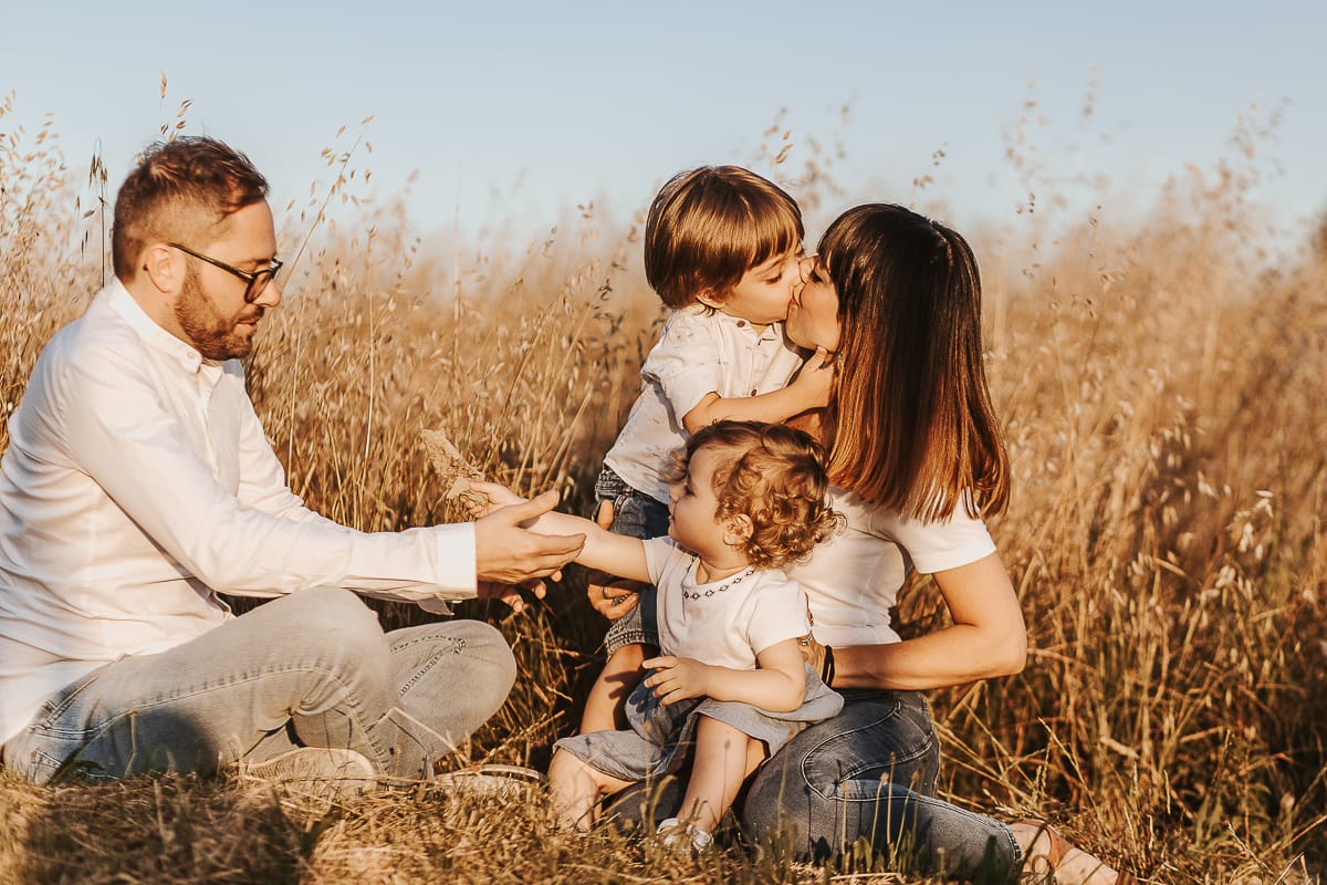 Un ritratto di famiglia al tramonto: Ilenia, Filippo, Edo e Camilla, uniti dal loro amore. Edo bacia la mamma.