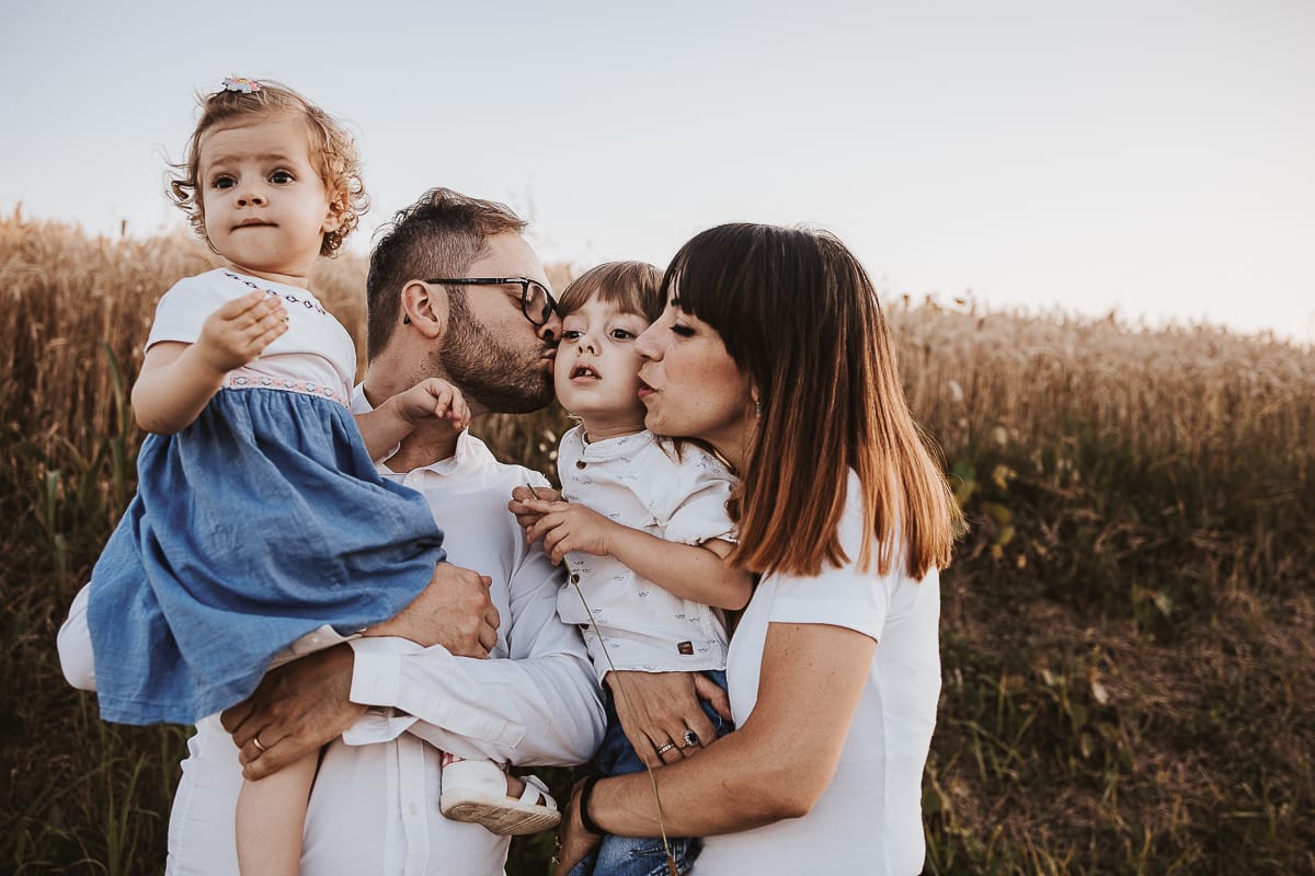 Un ritratto di famiglia al tramonto:Filippo tiene in braccio la piccola Camillae bacia Edo. La mma tiene in braccio Edo e lo bacia.
