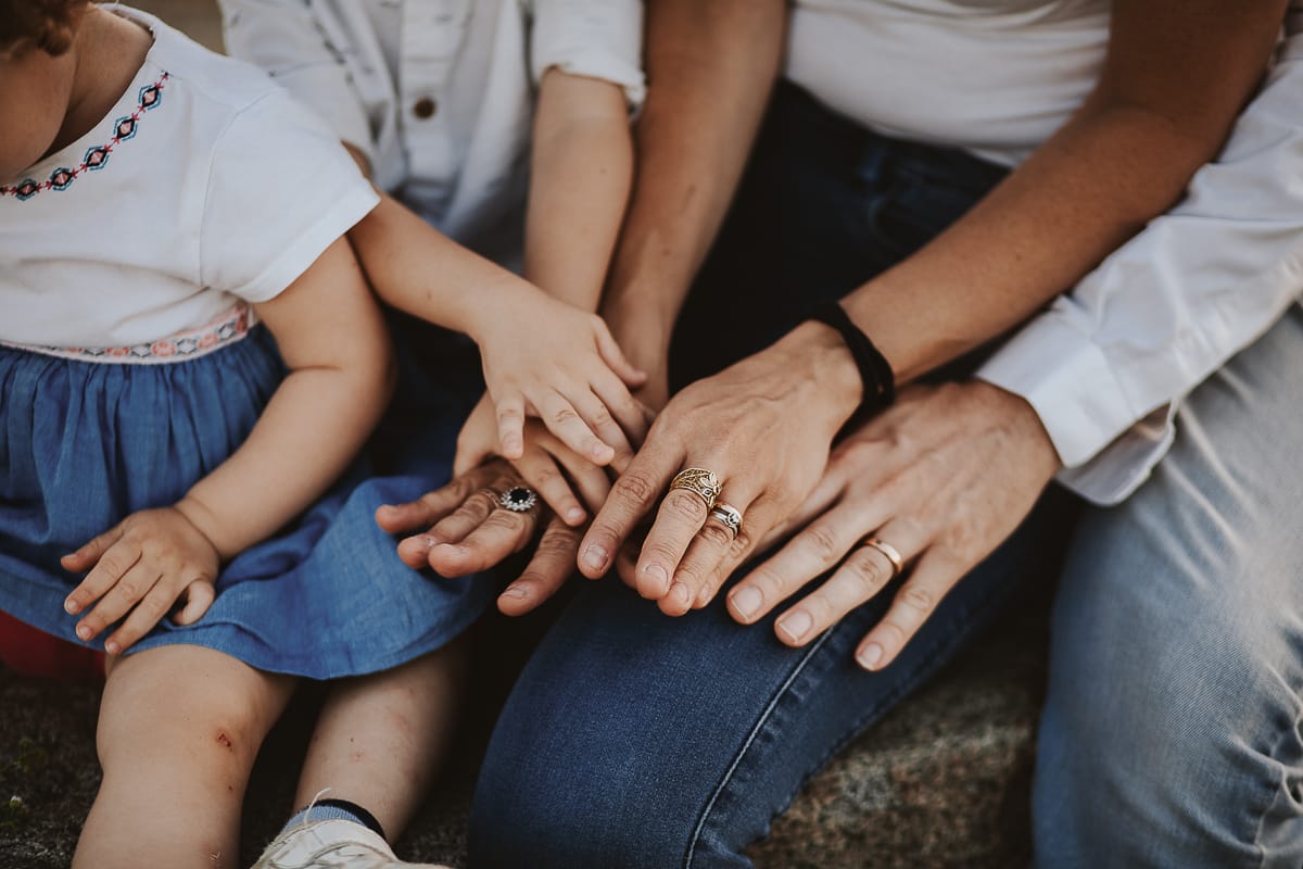 La famiglia si siede su una panchina dettaglio sulle mani.