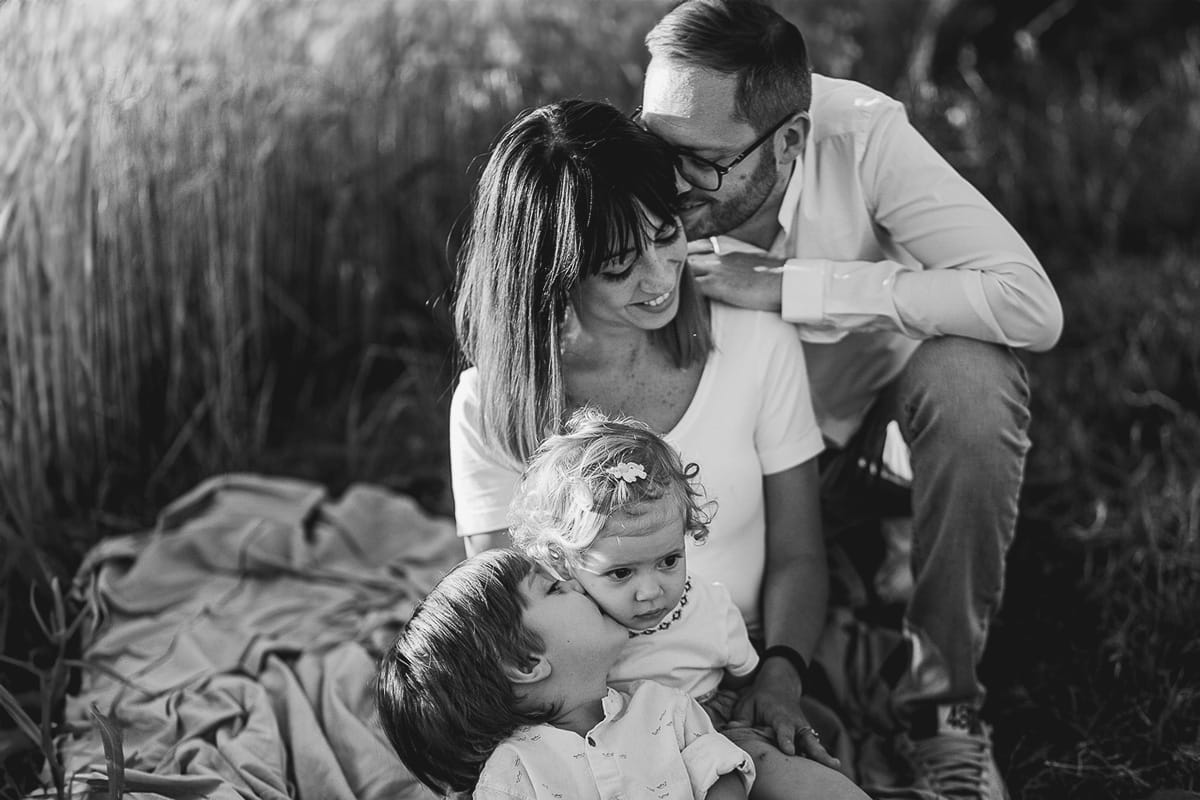Foto di Famiglia al Tramonto: Ilenia, Filippo, Edoardo e Camilla a Mombello di Torino. la famiglia seduta in un sentiero tra due campi di grano.