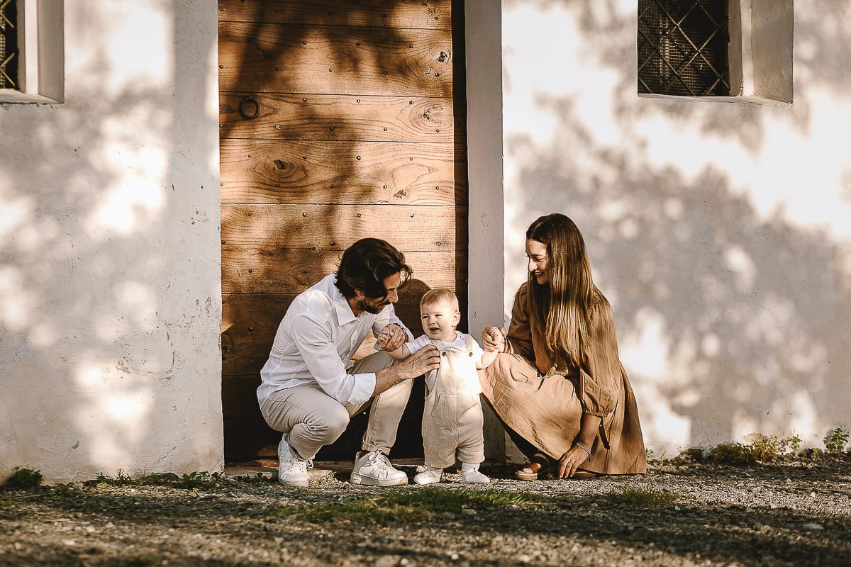 Servizio fotografico di famiglia a Torino: un tramonto dorato a Mombello di Torino. Chiara, Alessandro e il piccolo Leonardo davanti alla chiesa di San Lorenzo.