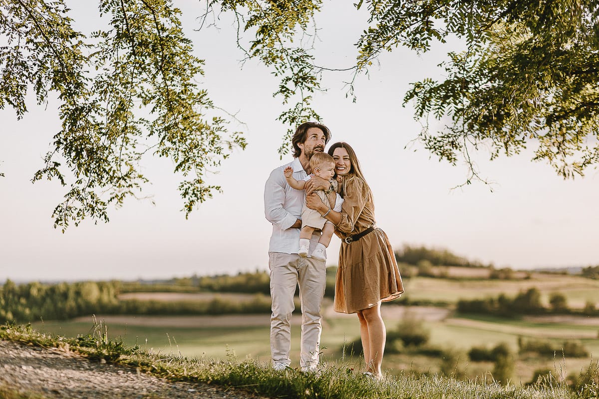 Servizio fotografico di famiglia a Torino: un tramonto dorato a Mombello di Torino. Chiara, Alessandro e il piccolo Leonardo davanti alla chiesa di San Lorenzo.