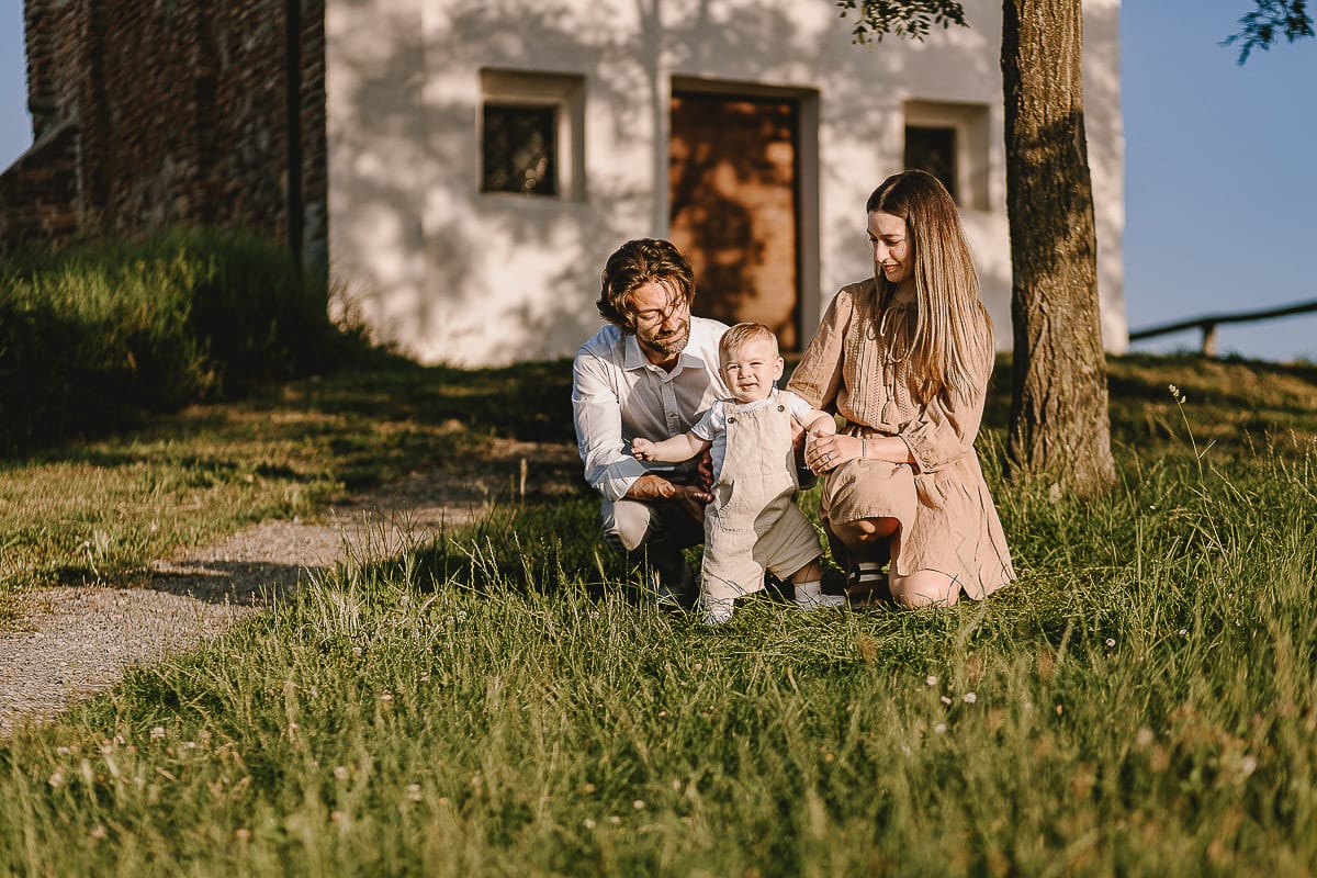 Servizio fotografico di famiglia a Torino: un tramonto dorato a Mombello di Torino. Chiara, Alessandro e il piccolo Leonardo davanti alla chiesa di San Lorenzo.