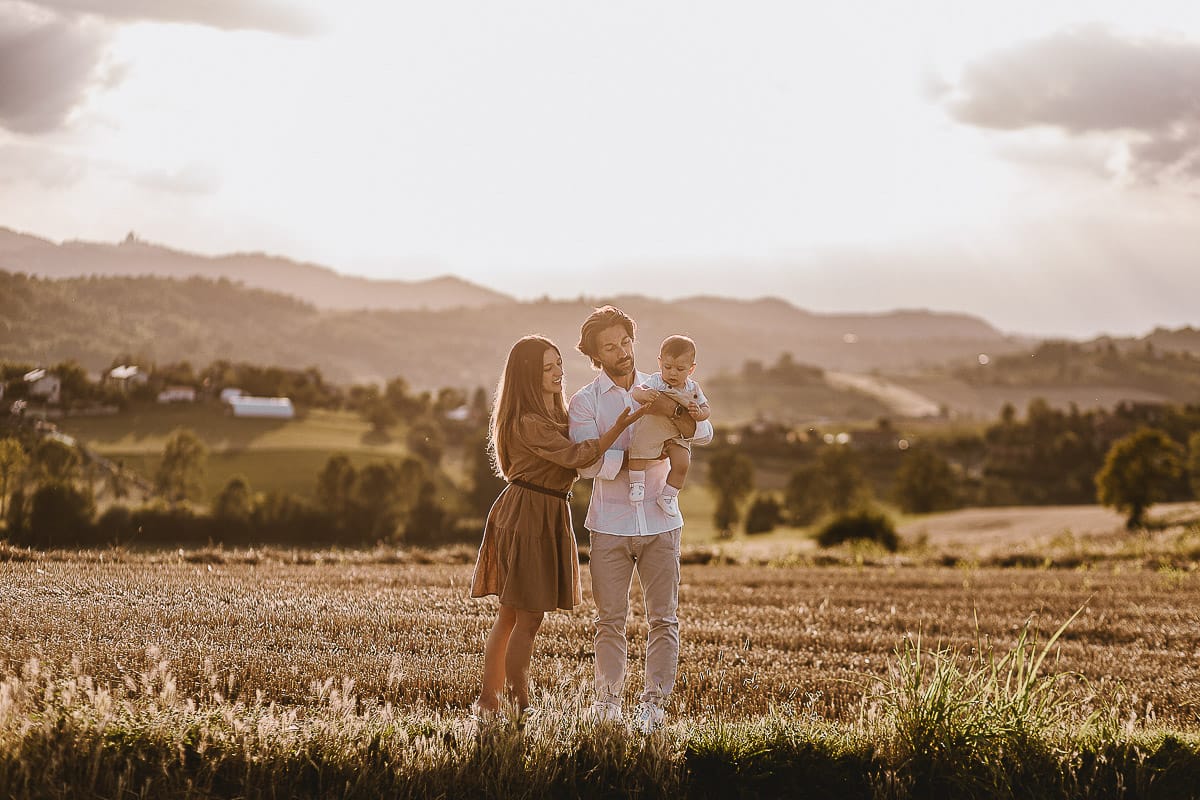 Servizio fotografico di famiglia a Torino: un tramonto dorato a Mombello di Torino. Chiara, Alessandro e il piccolo Leonardo davanti alla chiesa di San Lorenzo.