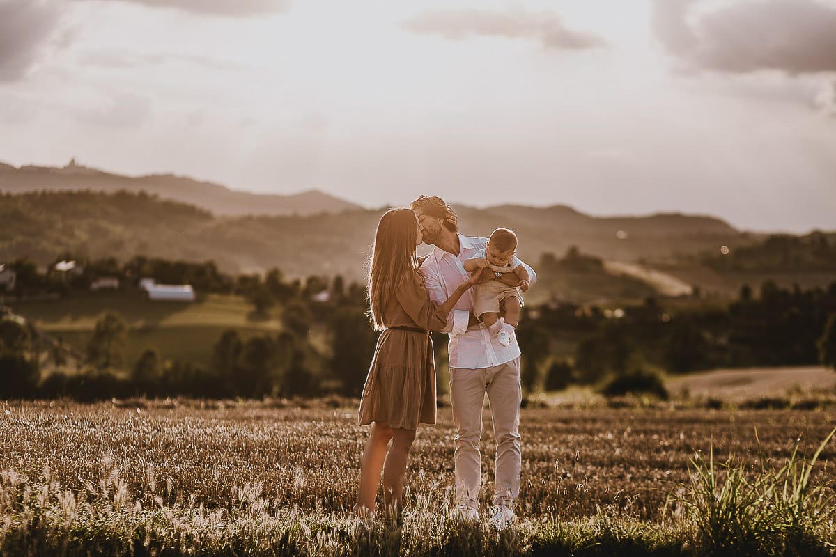 Servizio fotografico di famiglia a Torino: un tramonto dorato a Mombello di Torino. Chiara, Alessandro e il piccolo Leonardo davanti alla chiesa di San Lorenzo.