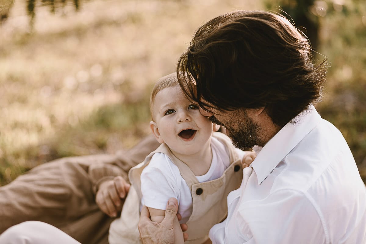 Servizio fotografico di famiglia a Torino: un tramonto dorato a Mombello di Torino. Chiara, Alessandro e il piccolo Leonardo sdraiati in un vigneto