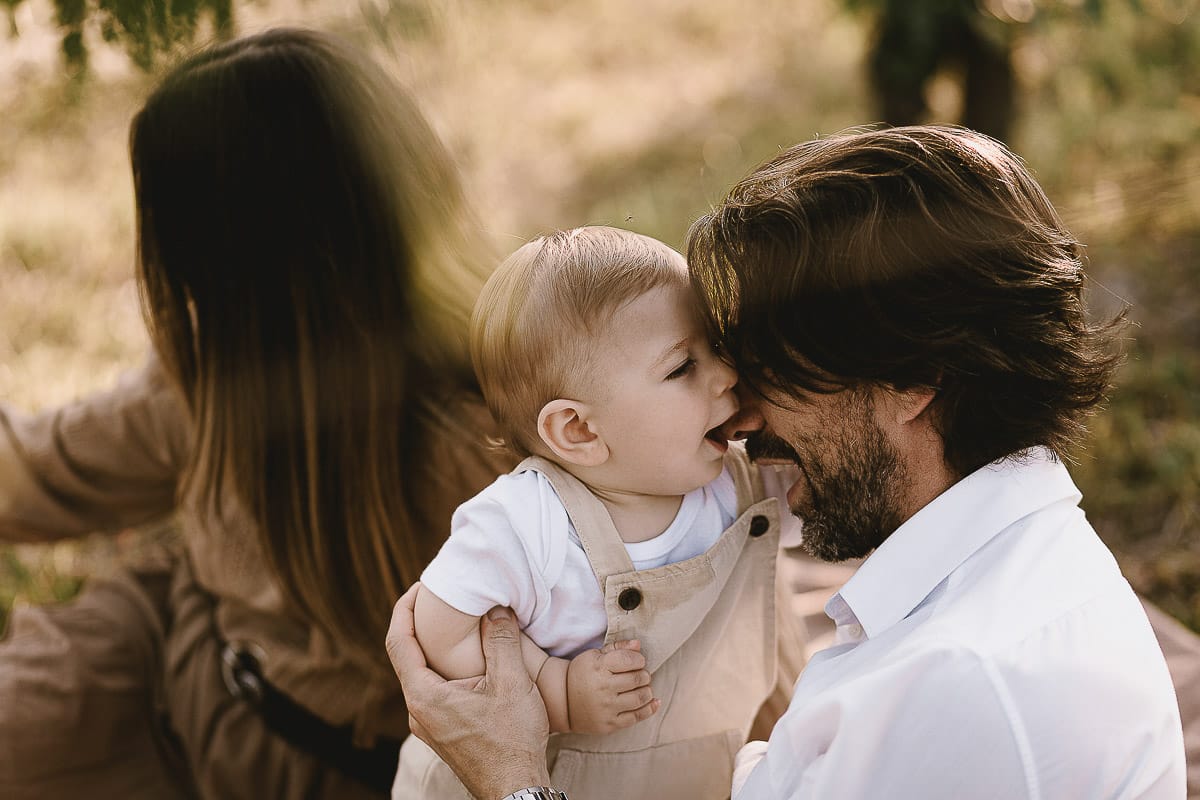 Servizio fotografico di famiglia a Torino: un tramonto dorato a Mombello di Torino. Chiara, Alessandro e il piccolo Leonardo sdraiati in un vigneto