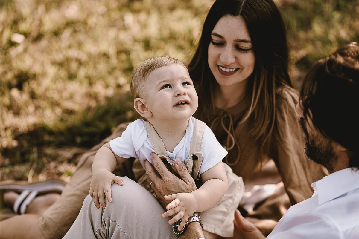 Servizio fotografico di famiglia a Torino: un tramonto dorato a Mombello di Torino. Chiara, Alessandro e il piccolo Leonardo sdraiati in un vigneto