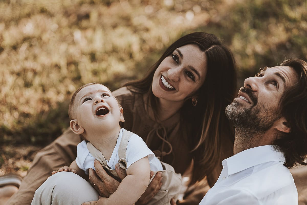 Servizio fotografico di famiglia a Torino: un tramonto dorato a Mombello di Torino. Chiara, Alessandro e il piccolo Leonardo sdraiati in un vigneto