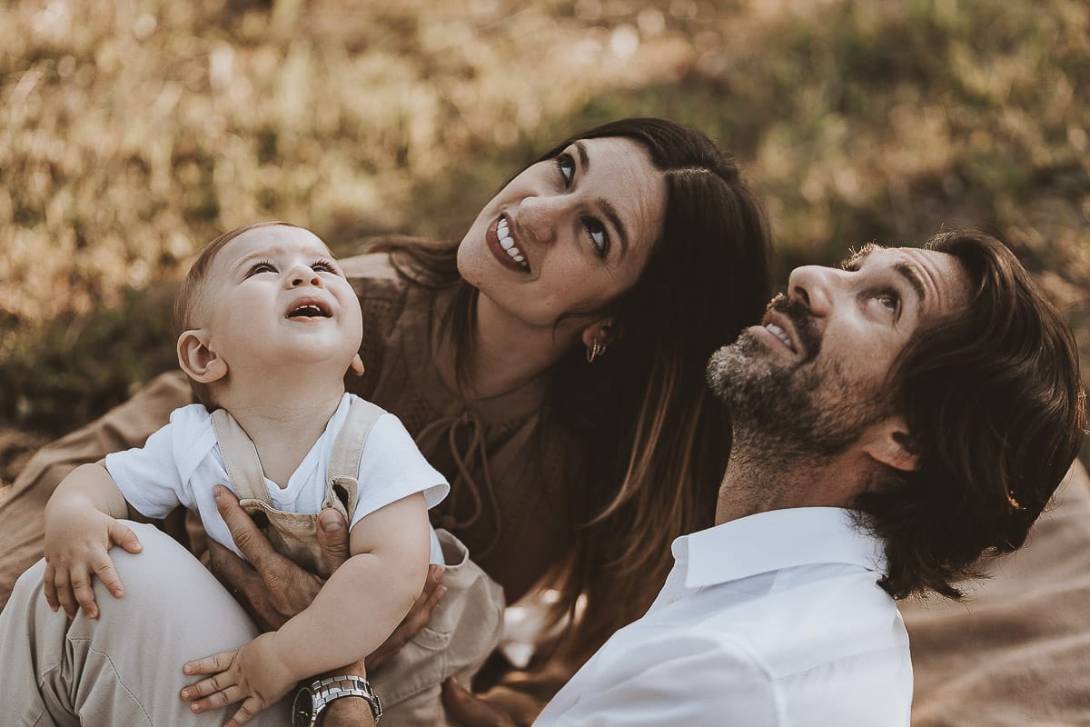 Servizio fotografico di famiglia a Torino: un tramonto dorato a Mombello di Torino. Chiara, Alessandro e il piccolo Leonardo sdraiati in un vigneto