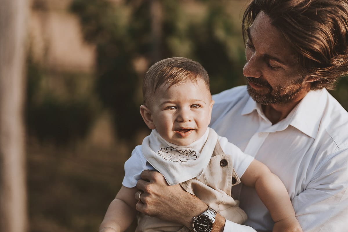 Servizio fotografico di famiglia a Torino: un tramonto dorato a Mombello di Torino. Alessandro e il piccolo Leonardo sdraiati in un vigneto