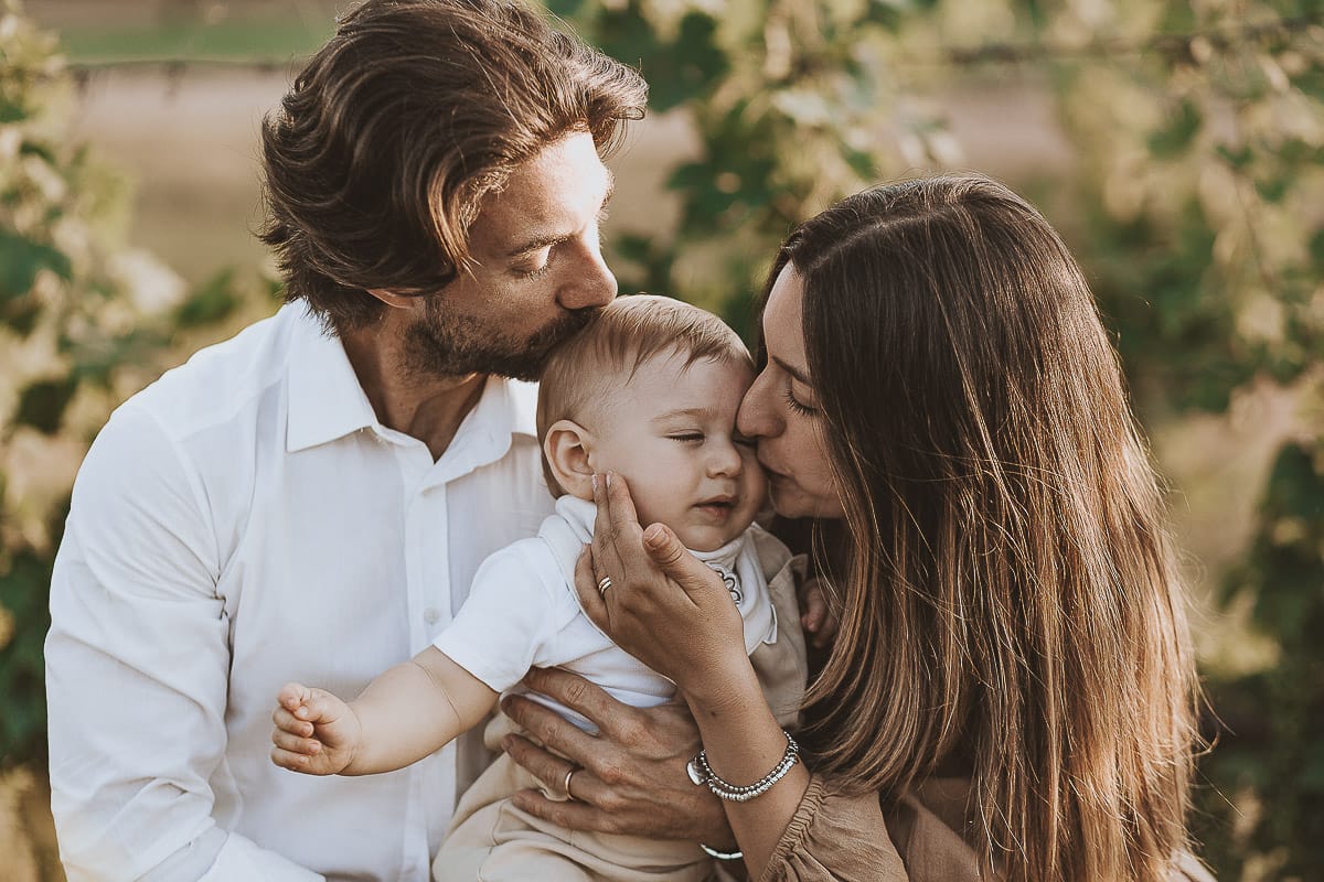 Servizio fotografico di famiglia a Torino: un tramonto dorato a Mombello di Torino. Chiara, Alessandro e il piccolo Leonardo sdraiati in un vigneto