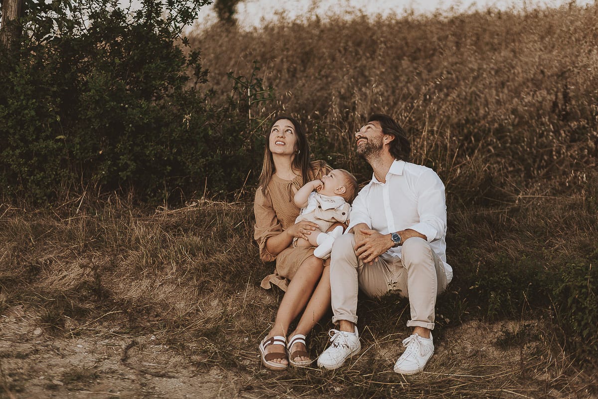 Servizio fotografico di famiglia a Torino: un tramonto dorato a Mombello di Torino. Chiara, Alessandro e il piccolo Leonardo seduti ai bordi di un campo di grano.