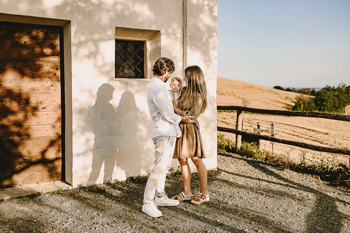 Servizio fotografico di famiglia a Torino: un tramonto dorato a Mombello di Torino. Chiara, Alessandro e il piccolo Leonardo davanti alla chiesa di San Lorenzo.