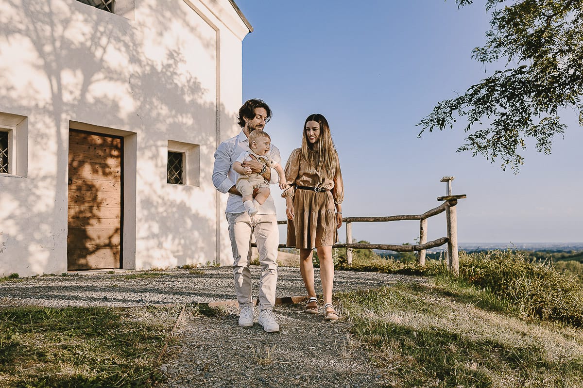 Servizio fotografico di famiglia a Torino: un tramonto dorato a Mombello di Torino. Chiara, Alessandro e il piccolo Leonardo davanti alla chiesa di San Lorenzo.