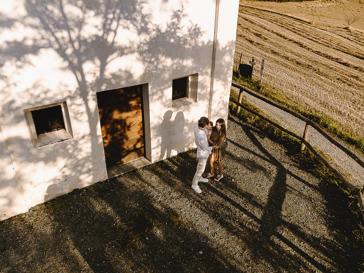 Servizio fotografico di famiglia a Torino: un tramonto dorato a Mombello di Torino. Chiara, Alessandro e il piccolo Leonardo davanti alla chiesa di San Lorenzo.