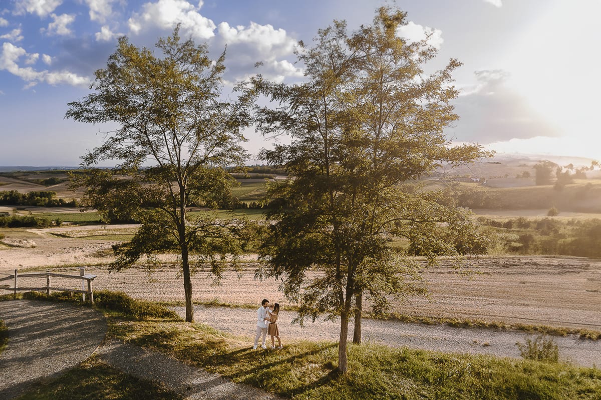 Servizio fotografico di famiglia a Torino: un tramonto dorato a Mombello di Torino. Chiara, Alessandro e il piccolo Leonardo in mezzo a due alberi