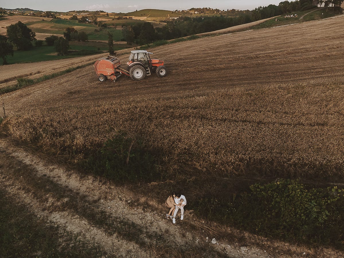 Servizio fotografico di famiglia a Torino: un tramonto dorato a Mombello di Torino. Chiara, Alessandro e il piccolo Leonardo seduti davanti ad un campo di grano