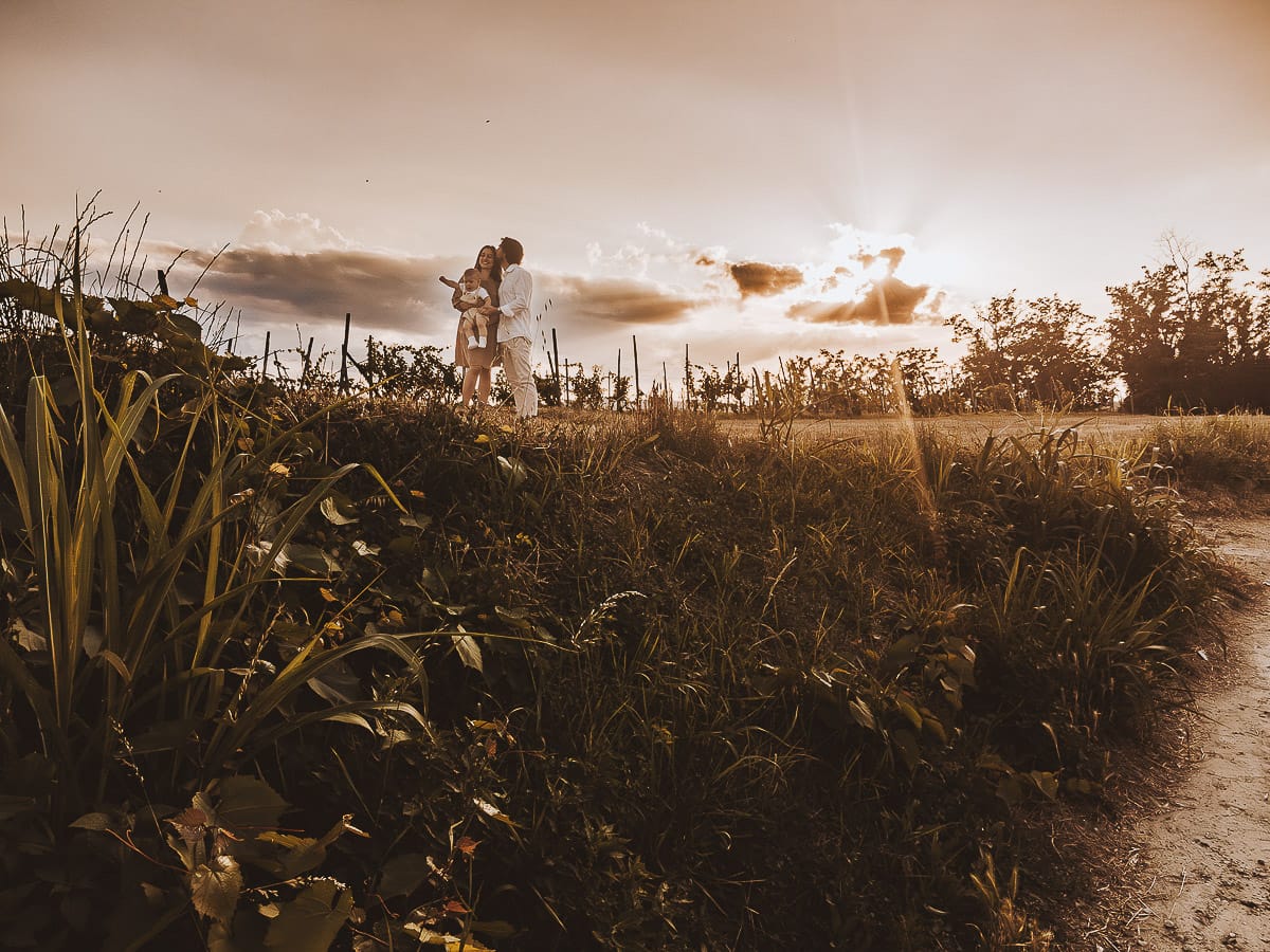 Servizio fotografico di famiglia a Torino: un tramonto dorato a Mombello di Torino. Chiara, Alessandro e il piccolo Leonardo in un campo. Foto dal drone.