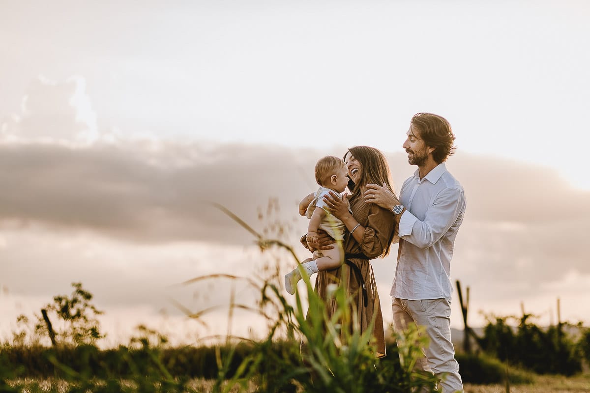 Servizio fotografico di famiglia a Torino: un tramonto dorato a Mombello di Torino. Chiara, Alessandro e il piccolo Leonardo in un campo