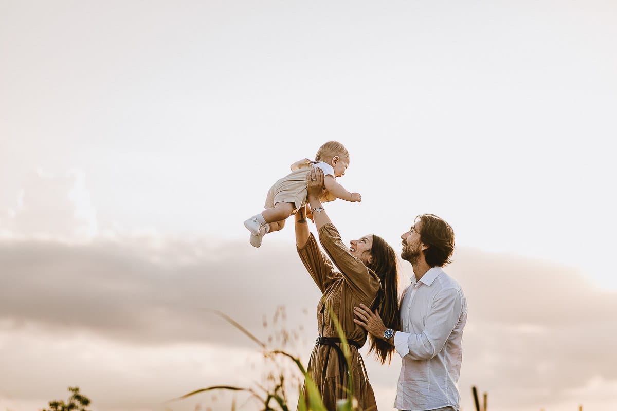 Servizio fotografico di famiglia a Torino: un tramonto dorato a Mombello di Torino. Chiara, Alessandro e il piccolo Leonardo in un campo