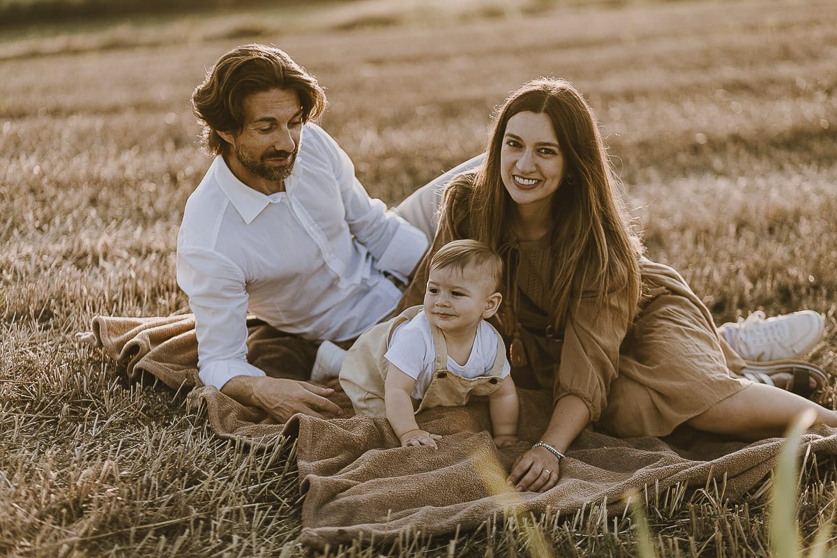 Servizio fotografico di famiglia a Torino: un tramonto dorato a Mombello di Torino. Chiara, Alessandro e il piccolo Leonardo in un campo