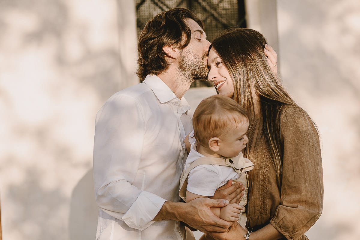 Servizio fotografico di famiglia a Torino: un tramonto dorato a Mombello di Torino. Chiara, Alessandro e il piccolo Leonardo davanti alla chiesa di San Lorenzo.