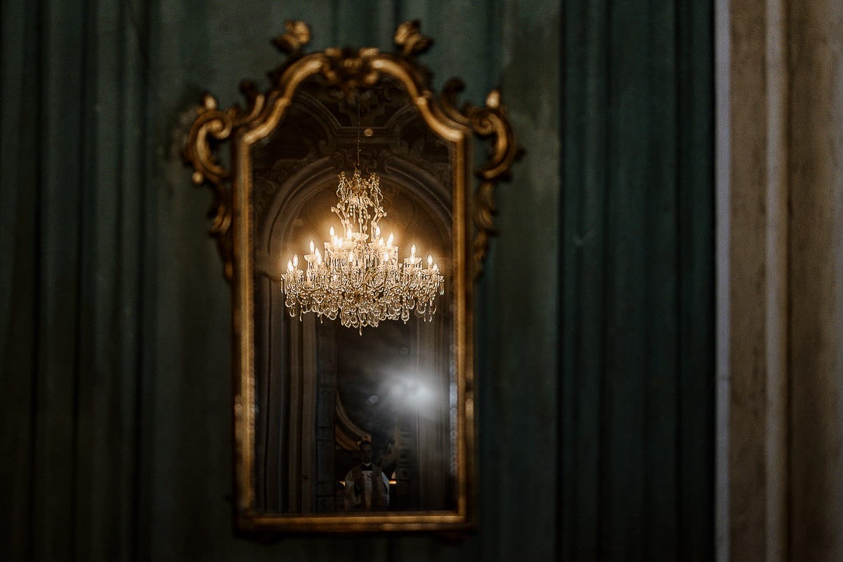 Matrimonio da favola al castello Canalis. Cerimonia. Dettaglio del sontuoso lampadario a gocce riflesso nello specchio.