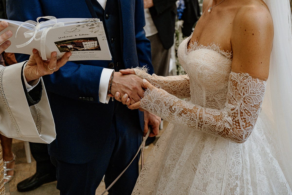 Matrimonio da favola al castello Canalis. Cerimonia. Sposi si danno la mano.