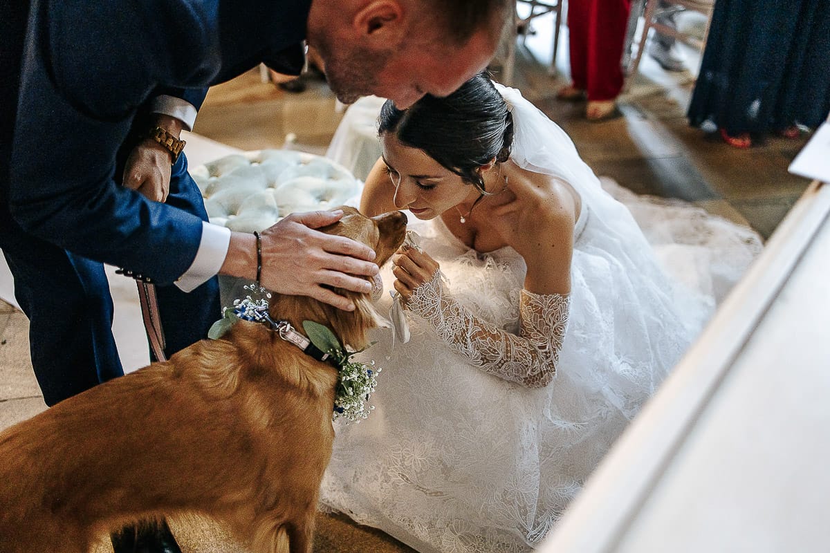 Matrimonio da favola al castello Canalis. Cerimonia. Sposa prende gli anelli dal collare della cagnolina.
