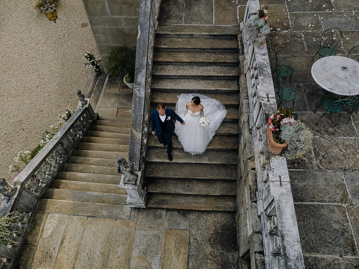 Matrimonio da favola al castello Canalis. Ritratto degli sposi dal drone. Sposi scendono lo scalone di pietra.